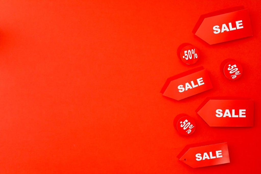 Red sale tags with 50% discounts on vibrant background for retail promotions.